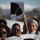 A woman holds an image of councilwoman and human rights activist Marielle Franco during a protest against her murder in the Mare Complex slum of Rio de Janeiro on March 18, 2018.